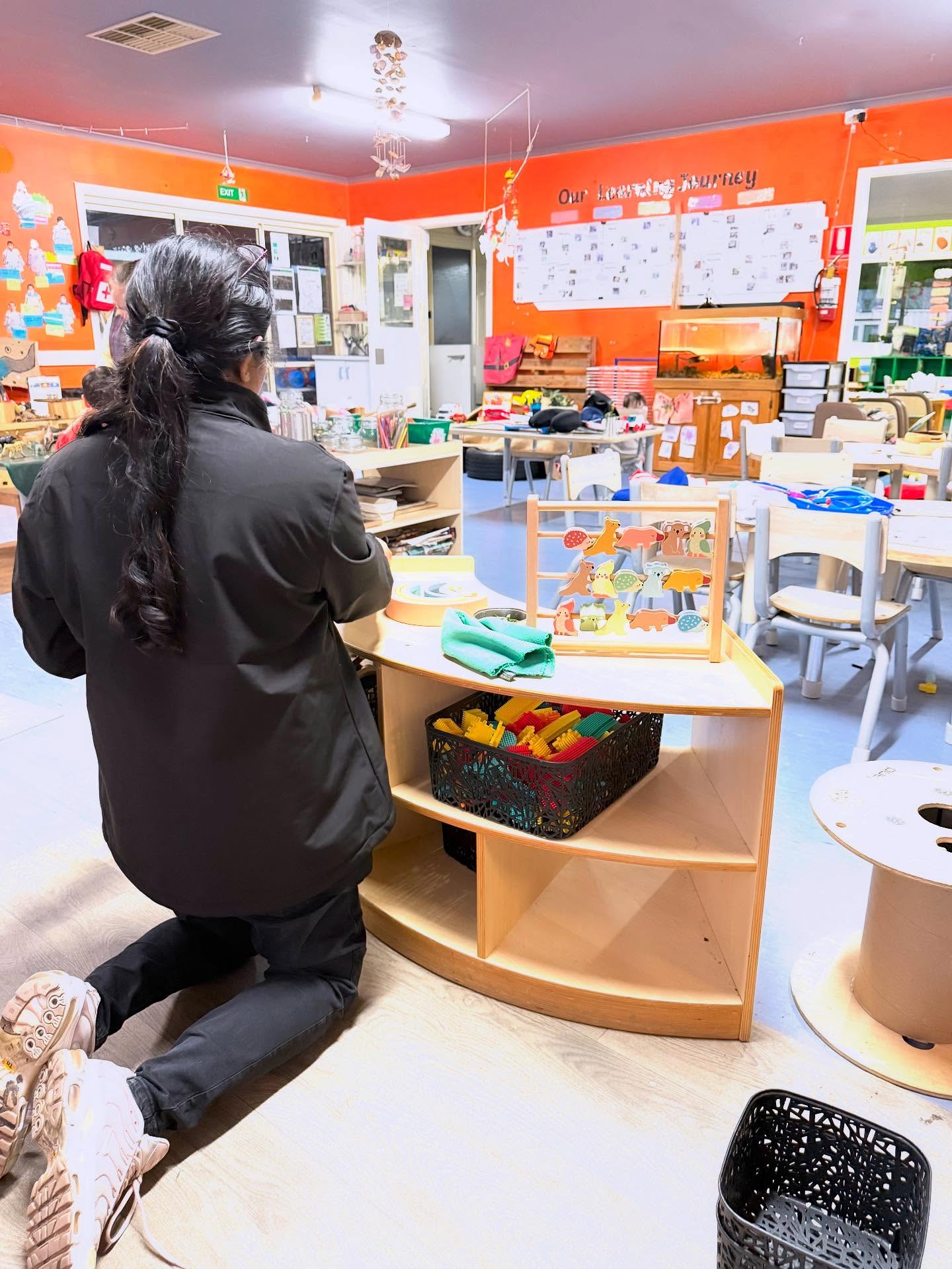 A child at the learning shelf in the Green Room
