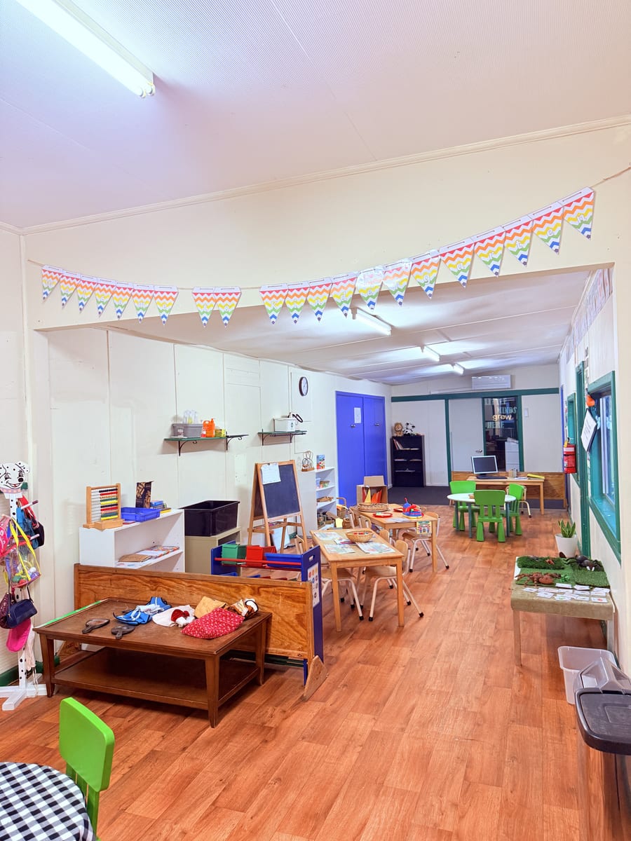 Preschool classroom with rainbow bunting and learning stations